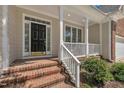 Inviting front porch with brick steps and black front door, offering a cozy entrance at 103 Temple Gate Dr, Cary, NC 27518