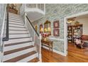 Bright foyer with wallpaper, hardwood floors, and a staircase leading to the second floor at 1100 Queensbury Cir, Durham, NC 27713