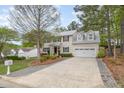 Inviting home exterior with a long driveway, attached garage, and manicured front lawn at 1208 Lexington Farm Rd, Apex, NC 27502