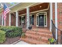 Inviting brick front porch with a welcome door and American flag at 124 Mantle Dr, Clayton, NC 27527