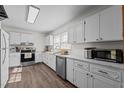 Well-lit white kitchen featuring stainless steel appliances, ample counter space, and hardwood floors at 1329 Mebane St, Burlington, NC 27217