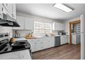 White kitchen featuring stainless steel appliances, ample counter space, and hardwood floors at 1329 Mebane St, Burlington, NC 27217