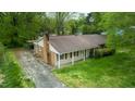 Aerial view of a single-story home with a brick chimney, carport, and concrete driveway at 133 Montree Ln, Graham, NC 27253