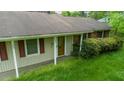Close-up of the front exterior with a glass paneled door and red shutters on the windows at 133 Montree Ln, Graham, NC 27253
