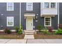 Close up of townhome with light green door, mulched landscaping and gray siding at 139 Callowhill Ln, Durham, NC 27713