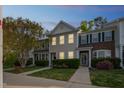 Charming townhome with cozy front yard and warm exterior lighting at dusk at 140 Cedar Elm Rd, Durham, NC 27713
