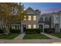 Inviting townhome with cozy front yard and warm exterior lighting at dusk at 140 Cedar Elm Rd, Durham, NC 27713
