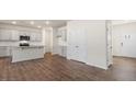 Open-concept kitchen features gray cabinets, a breakfast bar and stainless steel appliances at 144 Global Ave, Fuquay Varina, NC 27526