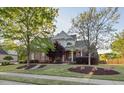Inviting brick home boasts a lush front lawn, mature trees, and a welcoming facade on a sunny day at 149 Country Mill Way, Fuquay Varina, NC 27526