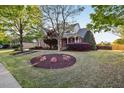Beautiful home with meticulously landscaped front yard, showcasing vibrant flower beds and mature trees on a sunny day at 149 Country Mill Way, Fuquay Varina, NC 27526