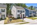 Two-story home with black shutters, a concrete driveway, a well-manicured lawn, and mature trees at 166 Yellow Jacket Rdg, Clayton, NC 27520