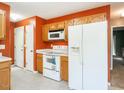 Functional kitchen with white appliances and wood cabinets at 1850 Crissy Ln, Graham, NC 27253