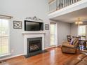 Cozy living room with fireplace, large windows, and hardwood floors at 1850 Crissy Ln, Graham, NC 27253