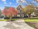 Charming brick home with manicured lawn and mature trees under a bright sky at 204 Oxford Mill Ct, Cary, NC 27518