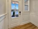 Bright entryway with glass front door, wood floors, and painted wainscoting at 223 Pond Vw Ct # 10, Fuquay Varina, NC 27526