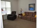 Cozy living room featuring comfortable seating and a window with natural lighting at 224 Eyam Hall Ln, Apex, NC 27502