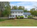 Charming two-story home featuring classic shutters, a well-manicured lawn, and lush landscaping at 2256 W Front St, Burlington, NC 27215
