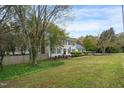 Two-story home features classic shutters, a well-manicured lawn, and mature trees at 2256 W Front St, Burlington, NC 27215