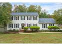 Charming two-story home featuring classic shutters, a well-manicured lawn, and lush landscaping at 2256 W Front St, Burlington, NC 27215