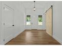 Bright entryway featuring wood floors, a sliding barn door, and natural light at 251 Sequoia Dr, Louisburg, NC 27549