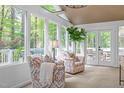 Bright sunroom with lots of natural light, stylish chairs, and views of the lush outdoors at 2805 Chelsea Cir, Durham, NC 27707