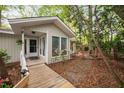 The home's entrance boasts a wooden ramp, leading to a covered porch with white railings and a glass-paneled front door at 2852 Rue Sans Famille, Raleigh, NC 27607