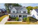 Aerial view of a two-story home featuring a manicured lawn, mature trees, and a private driveway at 3037 Freeman Farm Way, Rolesville, NC 27571