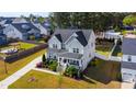 Aerial view of a two-story home with a landscaped yard, a long driveway, and a white fenced backyard at 3037 Freeman Farm Way, Rolesville, NC 27571