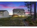 Exterior view of a two-story home with an expansive backyard featuring a deck, lawn, and well-maintained landscaping at 3037 Freeman Farm Way, Rolesville, NC 27571