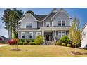 Charming two-story home with a welcoming front porch, stone accents, and professionally landscaped front yard at 3037 Freeman Farm Way, Rolesville, NC 27571