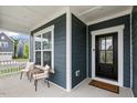 Inviting front porch featuring comfortable seating and an elegant black front door at 33 Highpointe Dr, Pittsboro, NC 27312