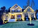 Inviting two-story home at twilight showcases manicured lawn and charming front porch at 3545 Donlin Dr, Wake Forest, NC 27587
