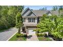 Two-story townhouse featuring stone veneer, attached garage, landscaped yard, and inviting curb appeal at 3667 Durwood Ln, Raleigh, NC 27604