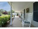 Cozy front porch featuring rocking chairs, decorative wreath, and serene views of the surrounding landscape at 38 Maple Cir, Pittsboro, NC 27312
