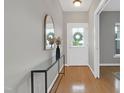 Bright foyer with hardwood floors, a stylish console table, and a decorative mirror at 3811 Yates Mill Trail, Raleigh, NC 27606