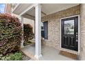 Inviting front porch with a cozy swing, brick accents, and a welcoming black front door at 3811 Yates Mill Trail, Raleigh, NC 27606
