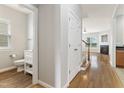 Hallway with hardwood floors leading to a bathroom and living space with a staircase at 3811 Yates Mill Trail, Raleigh, NC 27606