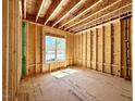 Unfinished bedroom with stud walls, exposed ceiling joists and one large window at 3817 Coach Lantern Ave, Wake Forest, NC 27587