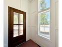 Bright entryway featuring a wood door with glass panels and natural light from a nearby window at 3817 Coach Lantern Ave, Wake Forest, NC 27587