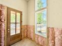 Bright entryway featuring a wood-framed glass door, white trim windows, and exposed insulation at 3817 Coach Lantern Ave, Wake Forest, NC 27587