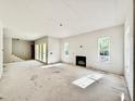 Open living room with fireplace, large windows, and sliding glass doors leading to an outdoor area at 3817 Coach Lantern Ave, Wake Forest, NC 27587