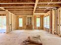 Unfinished living room with exposed ceiling joists and stud walls with two windows at 3817 Coach Lantern Ave, Wake Forest, NC 27587