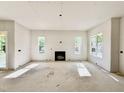 Spacious living room featuring a fireplace and ample natural light from large windows at 3817 Coach Lantern Ave, Wake Forest, NC 27587