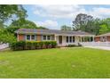Charming single-story home featuring a well-manicured lawn, covered carport, and classic brick and siding facade at 3913 Vesta Dr, Raleigh, NC 27603