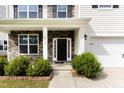 Inviting front porch with stone accents and columns, leading to a black front door at 3917 White Kestrel Dr, Raleigh, NC 27616