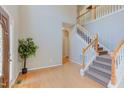 Bright foyer with hardwood floors, a staircase with white rails, and a decorative houseplant at 413 Palafox Dr, Chapel Hill, NC 27516