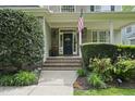 Close-up of front porch with brick steps, shrubs, and American flag waving at 429 Gambit Cir, Wake Forest, NC 27587