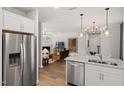 Open-concept kitchen with stainless steel appliances, connecting to a living room with a fireplace at 437 Providence Springs Ln, Fuquay Varina, NC 27526