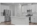 Modern kitchen with stainless steel appliances, white cabinets, a stylish island, and subway tile backsplash at 5016 Tura St, Raleigh, NC 27610