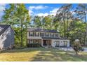 Classic two-story house with neutral siding and brick accents, framed by lush trees and a green lawn at 5315 Oakbrook Dr, Durham, NC 27713